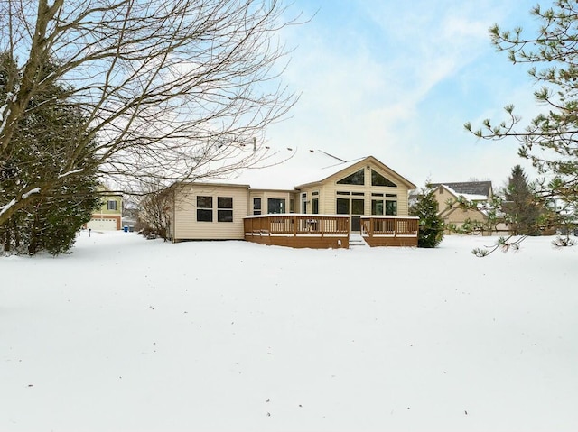 snow covered rear of property with a wooden deck