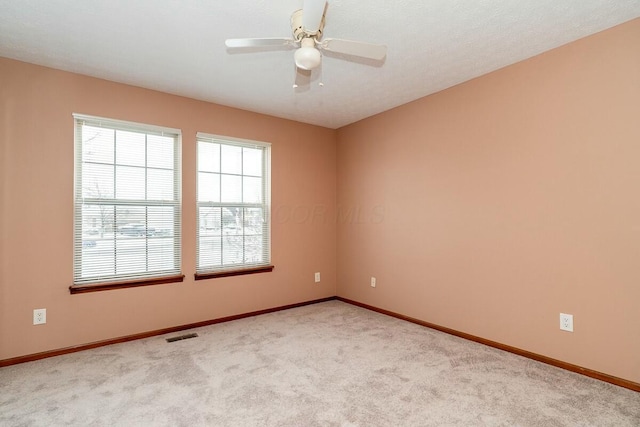 carpeted spare room with ceiling fan