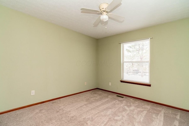 carpeted spare room featuring ceiling fan