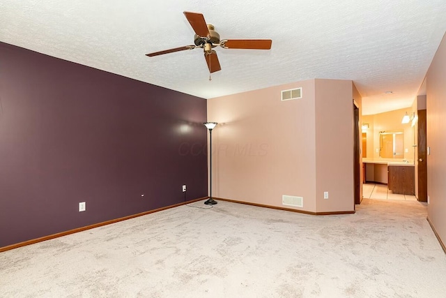 carpeted spare room with ceiling fan and a textured ceiling