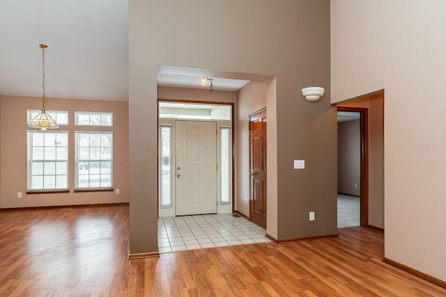 foyer with a chandelier, light hardwood / wood-style floors, and a high ceiling