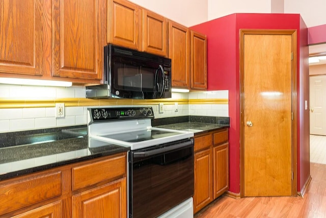 kitchen with decorative backsplash, light hardwood / wood-style floors, and white range with electric stovetop