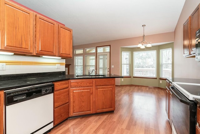 kitchen with black range with electric stovetop, sink, hanging light fixtures, white dishwasher, and a chandelier