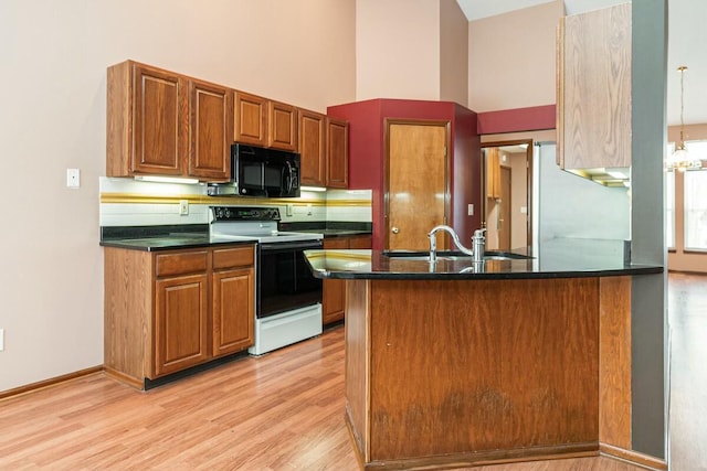 kitchen with kitchen peninsula, sink, white electric range oven, and light wood-type flooring