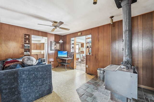 living room featuring ceiling fan and wood walls