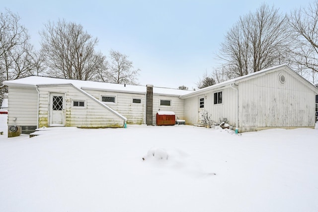 snow covered property with a hot tub