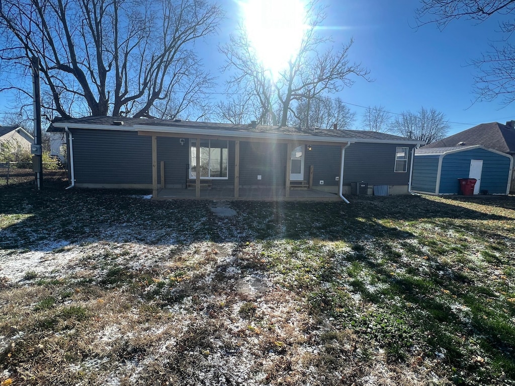 back of property featuring central air condition unit and a yard