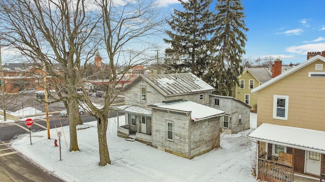 view of snow covered rear of property