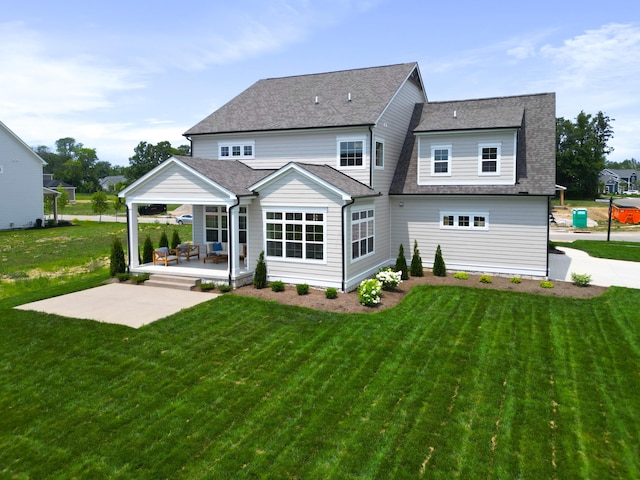 rear view of property featuring a porch and a lawn