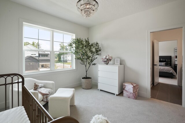 bedroom featuring carpet, a chandelier, and a crib