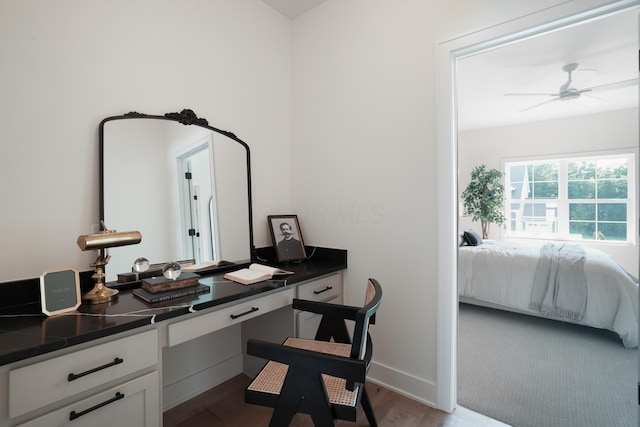 office space featuring ceiling fan, light hardwood / wood-style floors, and built in desk