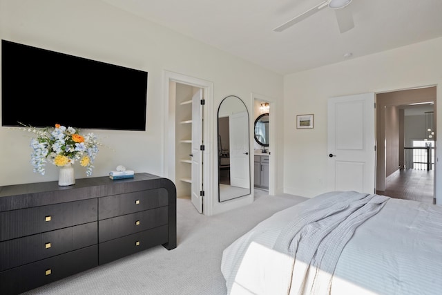 bedroom featuring ensuite bathroom, ceiling fan, and light colored carpet