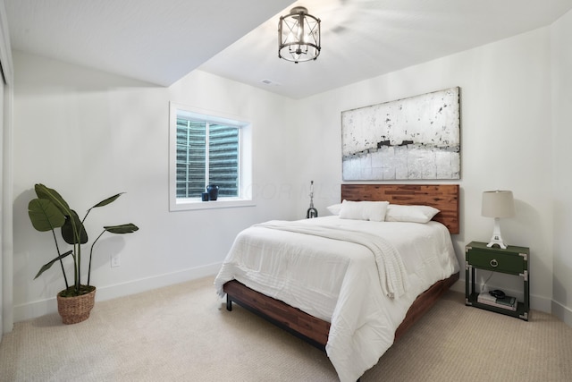 bedroom with a chandelier and light colored carpet