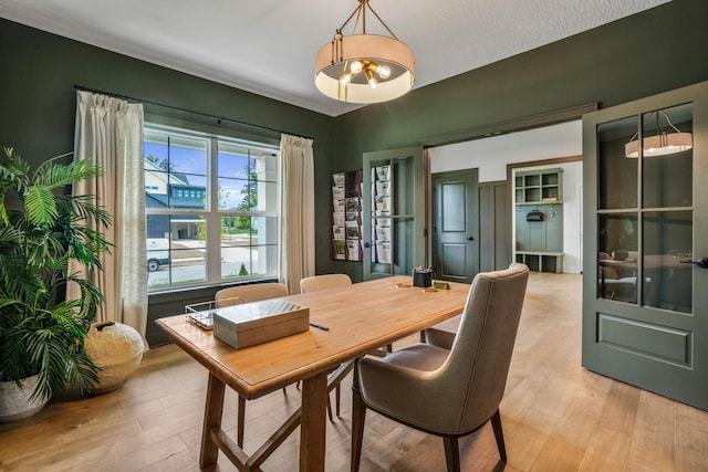 dining space featuring light hardwood / wood-style floors and an inviting chandelier