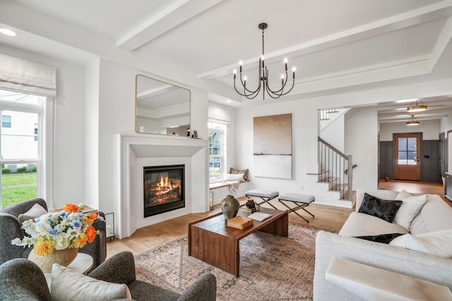 living room featuring beamed ceiling, light hardwood / wood-style floors, and an inviting chandelier