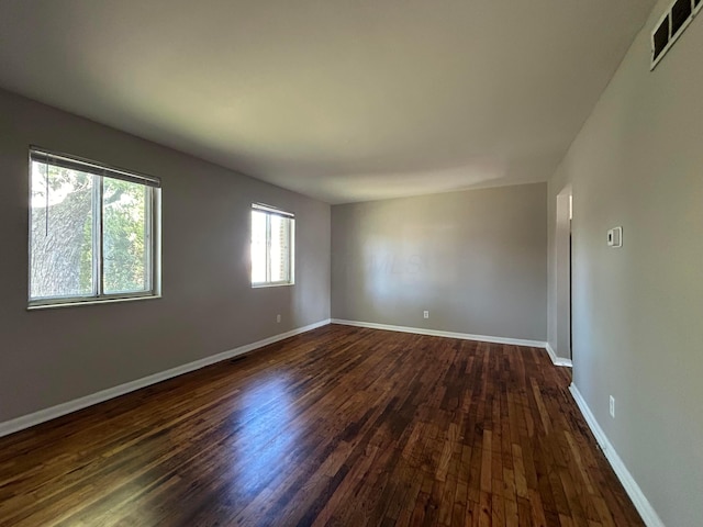 unfurnished room with dark wood-type flooring and a wealth of natural light