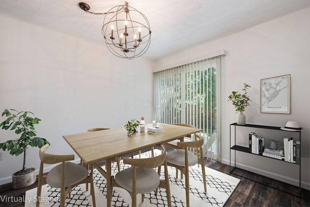 dining space featuring a textured ceiling, dark wood-type flooring, and a chandelier