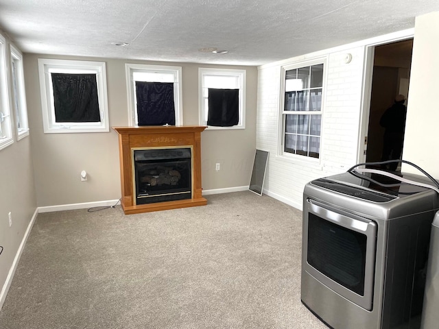 laundry room featuring carpet floors, a textured ceiling, and washer / clothes dryer