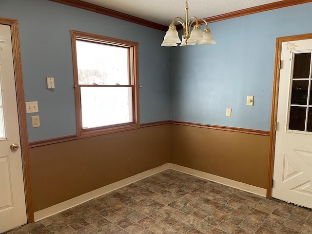 unfurnished dining area with crown molding and a chandelier