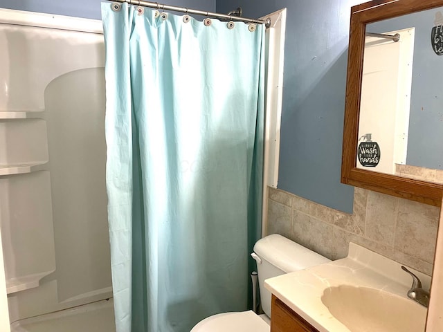 bathroom with vanity, curtained shower, toilet, and tasteful backsplash