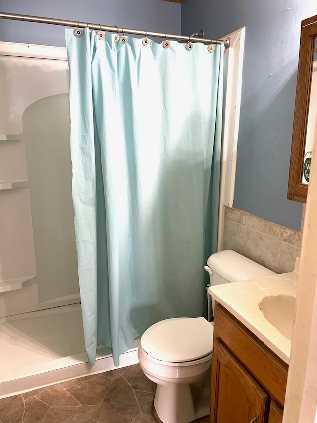 bathroom featuring tile patterned floors, vanity, toilet, and walk in shower