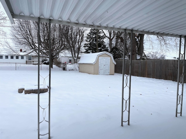 snowy yard featuring a shed