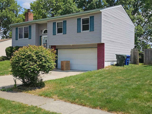 raised ranch featuring a front lawn and a garage