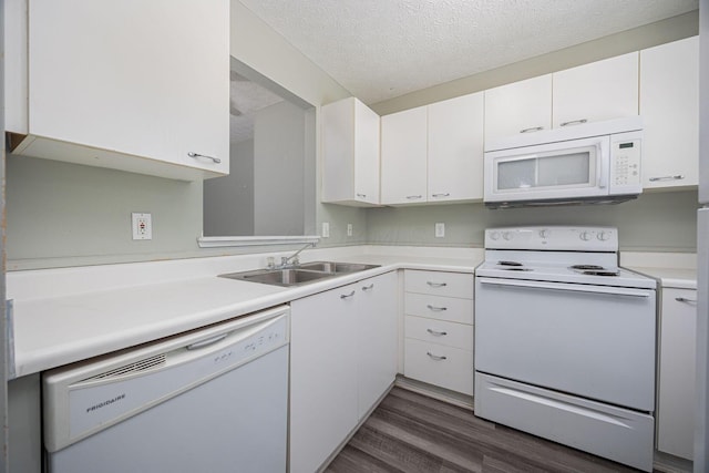 kitchen with white appliances, white cabinets, sink, a textured ceiling, and dark hardwood / wood-style flooring