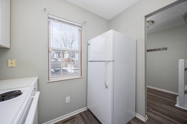 kitchen with white cabinets, white fridge, dark hardwood / wood-style floors, and a textured ceiling