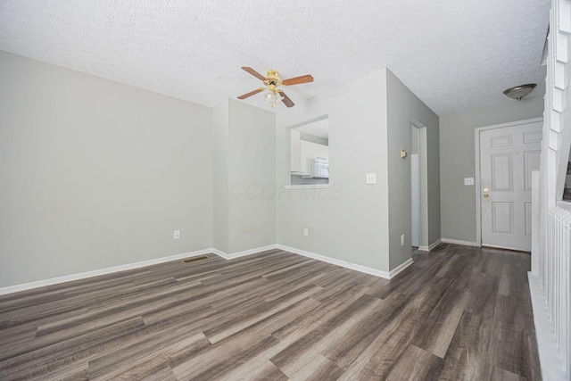 empty room with a textured ceiling, dark hardwood / wood-style flooring, and ceiling fan