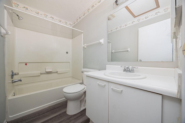 full bathroom with hardwood / wood-style floors, a textured ceiling, toilet, vanity, and shower / bathtub combination