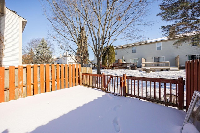 yard layered in snow with a wooden deck