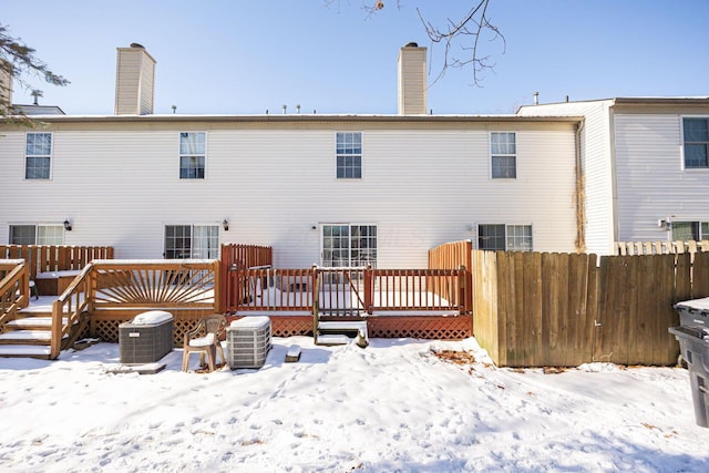 snow covered rear of property with central air condition unit and a deck