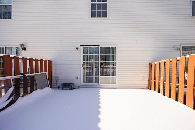 snow covered house featuring a patio area