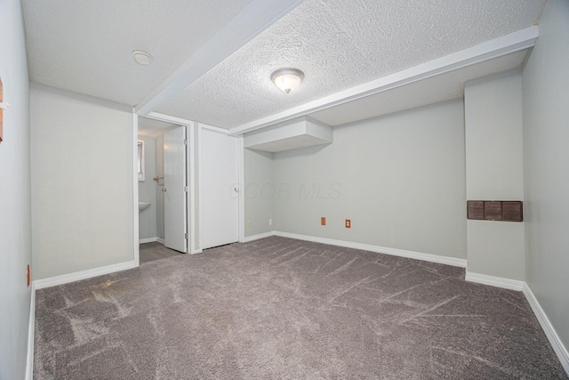 basement featuring a textured ceiling and dark carpet