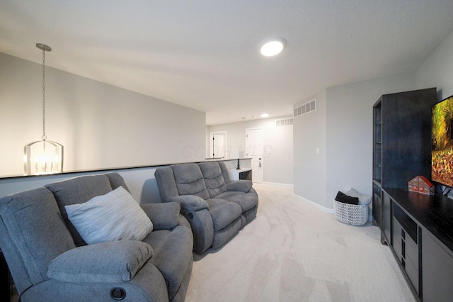 carpeted living room with a notable chandelier