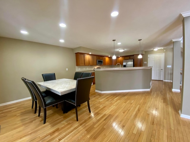 dining space with sink and light hardwood / wood-style flooring