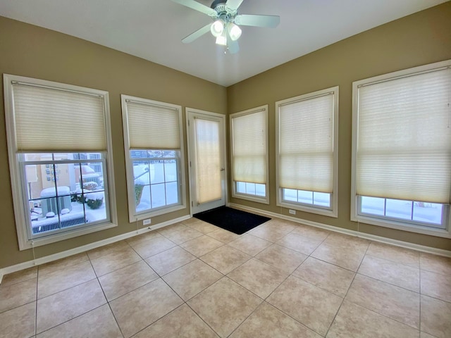 doorway to outside featuring ceiling fan and light tile patterned flooring