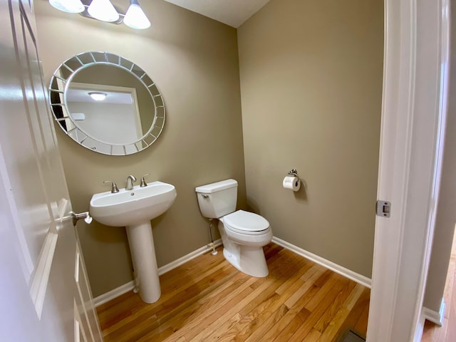 bathroom featuring hardwood / wood-style floors, toilet, and sink