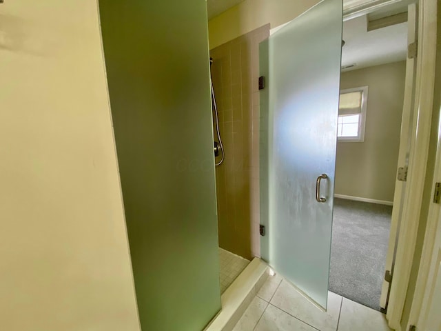 bathroom with tile patterned flooring and a shower with shower door