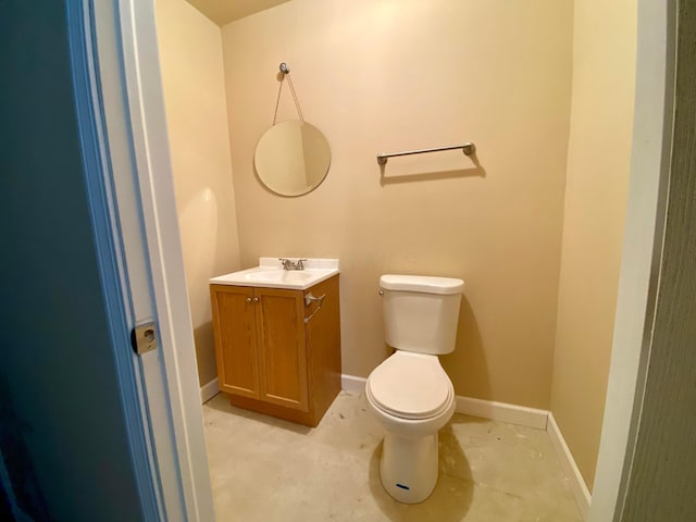 bathroom featuring concrete flooring, vanity, and toilet