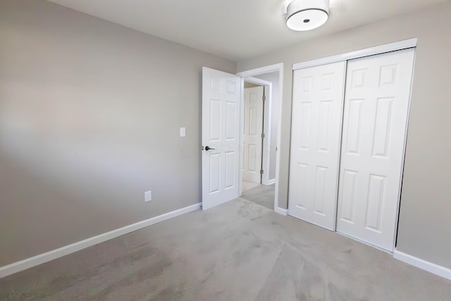 unfurnished bedroom featuring light carpet and a closet