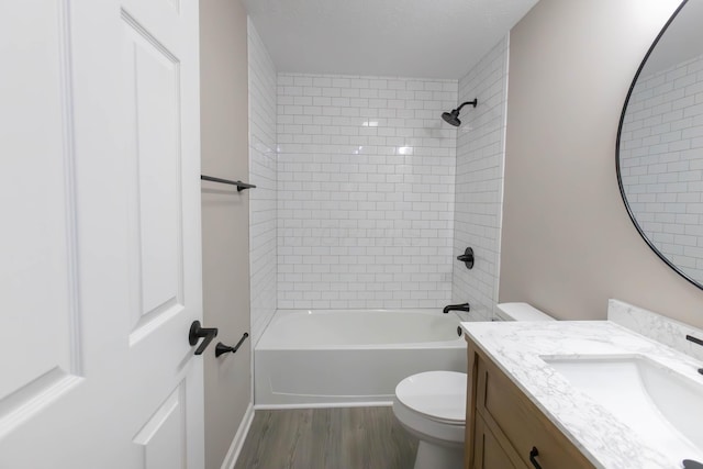 full bathroom featuring vanity, toilet, wood-type flooring, and tiled shower / bath