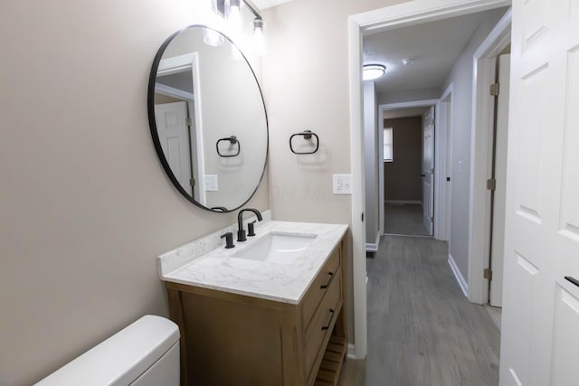 bathroom featuring toilet, vanity, and hardwood / wood-style flooring