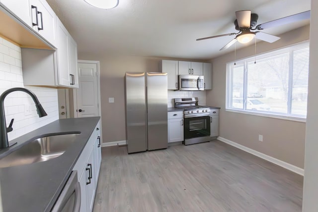 kitchen featuring white cabinets, stainless steel appliances, and tasteful backsplash