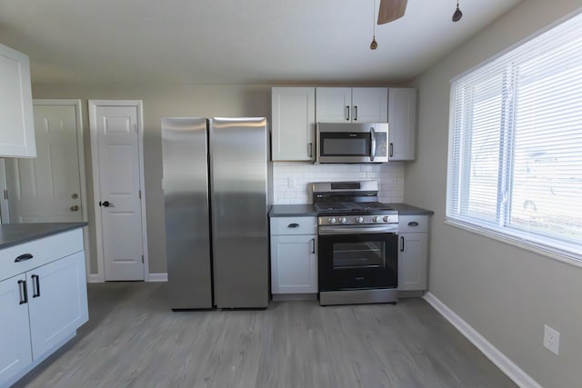 kitchen with backsplash, plenty of natural light, white cabinetry, and stainless steel appliances