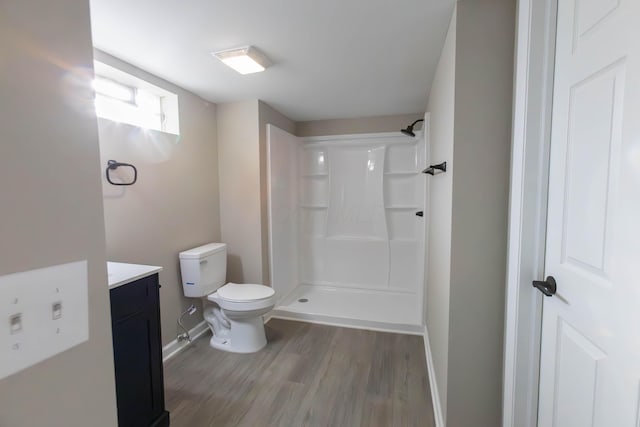 bathroom featuring vanity, toilet, wood-type flooring, and walk in shower