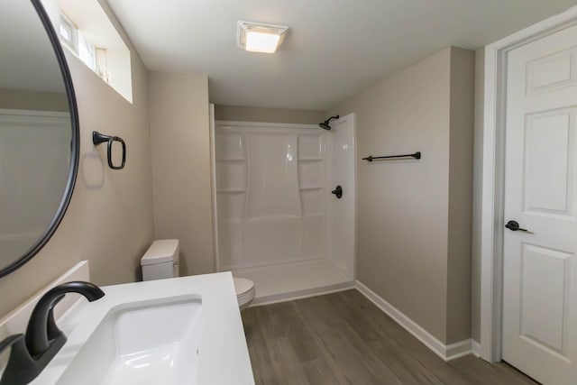 bathroom featuring toilet, wood-type flooring, sink, and walk in shower