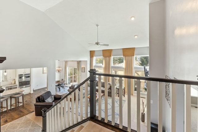 hallway featuring high vaulted ceiling and light hardwood / wood-style floors