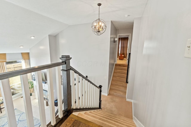 staircase with carpet floors, a notable chandelier, and vaulted ceiling